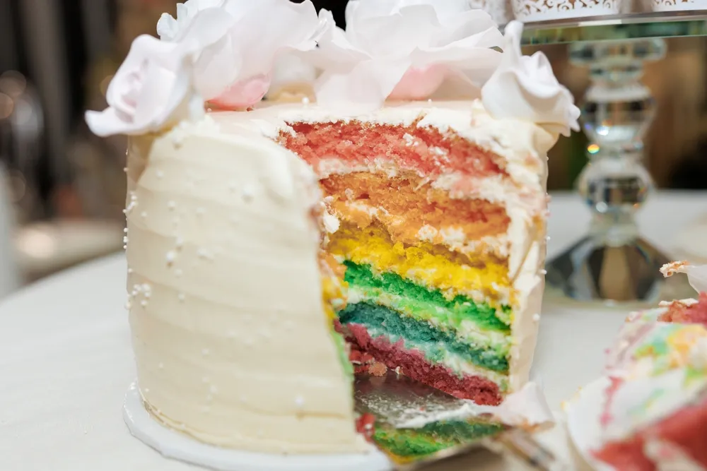 Modern multi-tier cake decorated in gradient colors with abstract textures and metallic accents