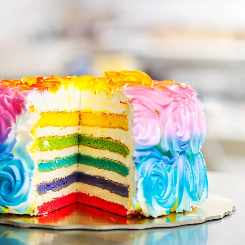 Modern multi-tier cake decorated in gradient colors with abstract textures and metallic accents