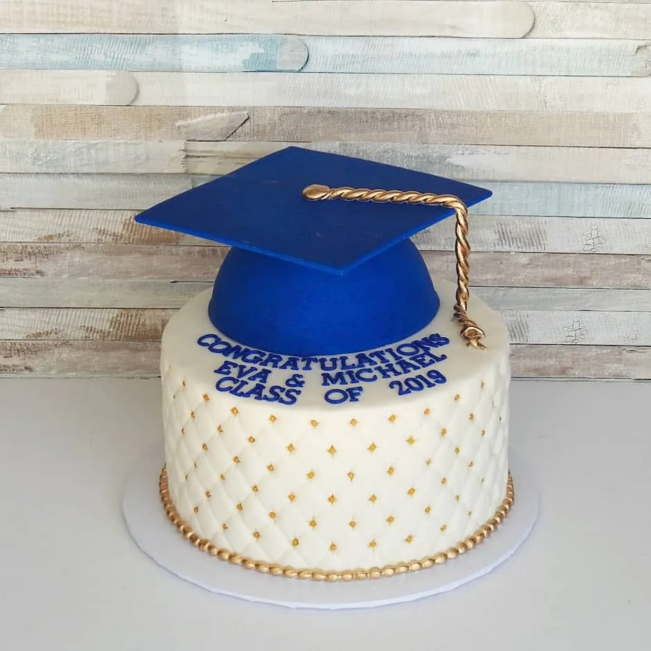 White quilted graduation cake with a blue fondant cap, gold tassel and personalized Class of 2019 message.